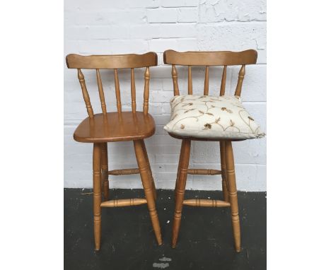 Two Windsor style spindle back high stools together with a cream cushion