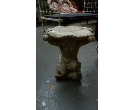 A compostition stone statue of a faun holding aloft a square top in the form of a cushion 46cmH