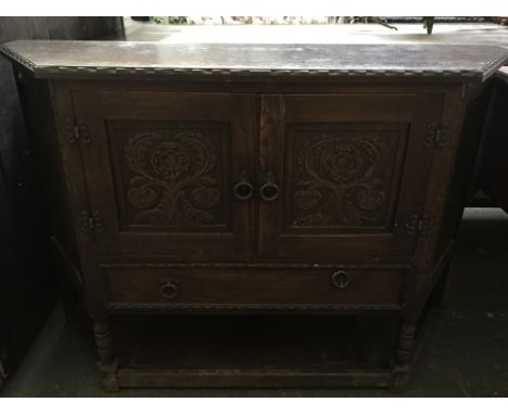 A sideboard comprising two double doors with foliate carving and shelf below 120 x 36 x 80cmH