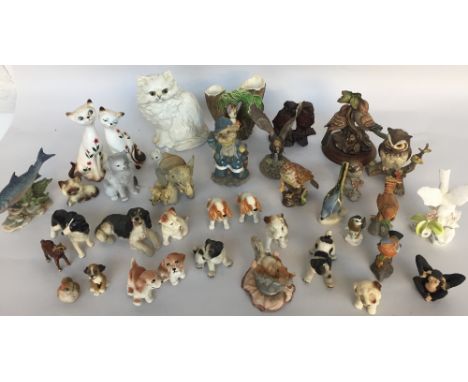 A quantity of figurines both wooden and ceramic including dogs, cats, birds and other animals