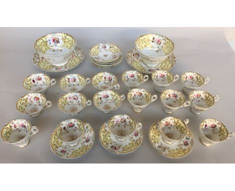 An early Victorian London pattern part tea service of yellow and gilt design with hand painted floral sprays over cream groun