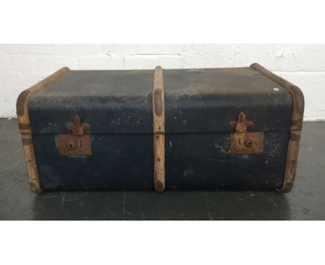 A blue canvas and wooden bound cabin trunk with leather handles bearing some labels 46x76x30cm 