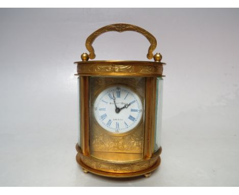 A MINIATURE ELLIOT AND SON BRASS OVAL CASED CARRIAGE CLOCK, the enamel dial with blue Roman numerals and chapter ring, marked