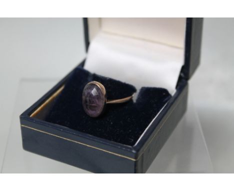 AN ANTIQUE YELLOW METAL AND AMETHYST INTAGLIO RING,  carved from the inside of the stone, marked 9c to band, ring size K 1/2