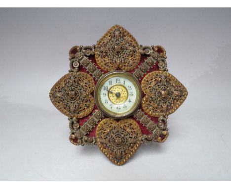 AN ORNATE 19TH CENTURY DRESSING TABLE CLOCK, the shaped frame with pierced plated embellishment, easel back, by British Unite