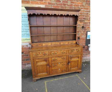 A 19TH CENTURY OAK DRESSER, the enclosed plate rail with a range of five spice drawers above a lower section with six drawers