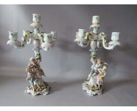 A PAIR OF CONTINENTAL PORCELAIN FIGURAL CANDELABRA, with applied floral and gilt embellishment, H 36 cm, S/D
