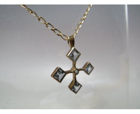 A HALLMARKED 9 CARAT GOLD PENDANT, set with aquamarine style stones and a central seed pearl all on a hallmarked 9 carat gold