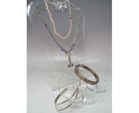 A HALLMARKED SILVER BANGLE WITH ENGRAVED DECORATION, together with a hallmarked silver triple inter locking bangle, white met