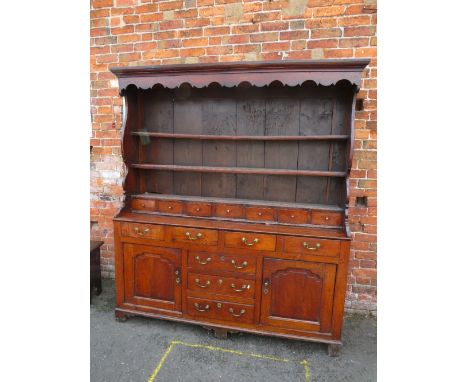 A GEORGIAN OAK DRESSER, the full plate rack with a range of seven spice drawers, the lower section with an arrangement of sev