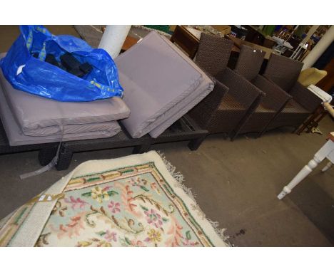 A four piece faux rattan garden set comprising of two seater sofa and two armchairs and a lounger
