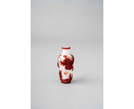A CHINESE RED OVERLAY GLASS 'DRAGON' SNUFF BOTTLEQIANLONG 1736-95The tapering milky-white body overlaid in dark ruby-red with