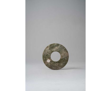 A CHINESE CELADON JADE DISC, BILATE ZHOU DYNASTYThe green mottled disc carved to both sides with a pattern of comma spirals i