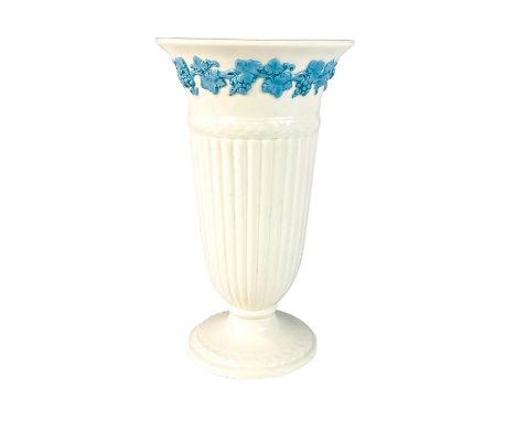 Lovely cream colored vase with raised grapevine motif in light blue.Wedgwood of Etruria factory mark on the bottom. Issued: 1