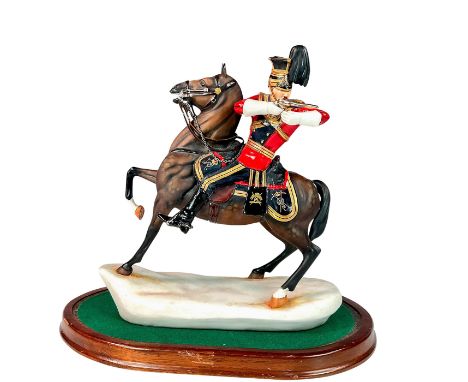 Modelled as a soldier in a red military uniform discharging his pistol from horseback. Hand painted with gold and silver gilt