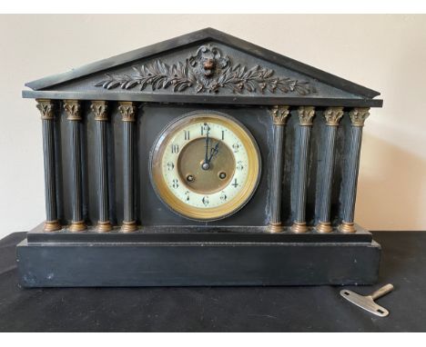 A 19thC black slate mantle clock with six Corinthian columns to the front and a white enamelled chapter dial. 27cms h x 15cms