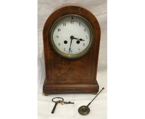 An Edwardian inlaid mahogany mantle clock with enamel face, Arabic numerals and French made movement. 3cms h x 19cms w x 13cm