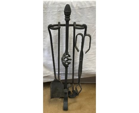 Wrought iron fireside tools set of 4 on stand, 70cms h.Condition ReportSigns of use, minor surface rust, no noticeable issues
