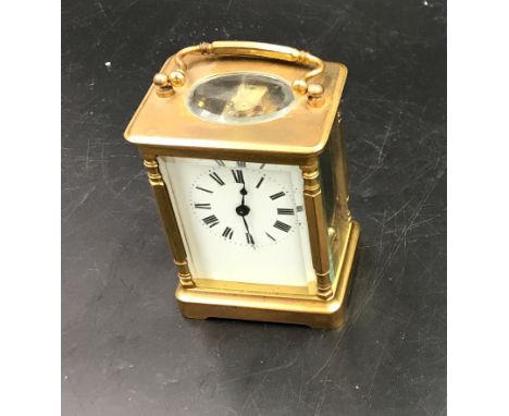 A brass carriage clock with Swiss movement. 14cms h with handle up. Key included. Winds and goes. Includes leather case.Condi