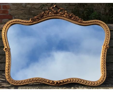 A decorative gilt framed wall mirror with floral bow decoration to the top. 100cms w x 76cms h.Condition ReportVery good, not