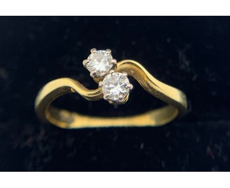 An 18ct two stone cross over diamond ring. Size K/L. 2.3gms.Condition ReportGood condition.