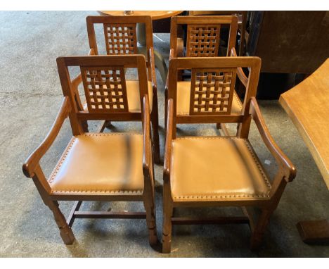 Four Robert ''Mouseman'' Thompson oak carver dining chairs each with lattice carved back and close stud leather upholstery on