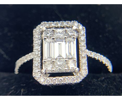 An 18ct white gold ring set with 3 baguette cut diamonds to centre. Size O. 3.8gms.Condition ReportGood condition.