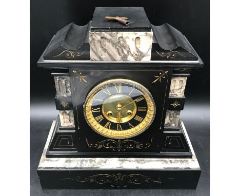 A slate and marble mantle clock with brass face, Roman numerals and 10cms face dial. Ht 35cms x 34cms w x 15cms d.Condition R