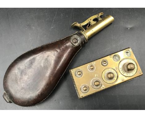 A leather and brass gunpowder flask 20cms l and a part set of brass weights 2gms to 100gms.Condition ReportWeights block miss