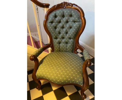 A Victorian mahogany framed button upholstered armchair with carved back. Height to seat 38cms, height to back 103cms, width 
