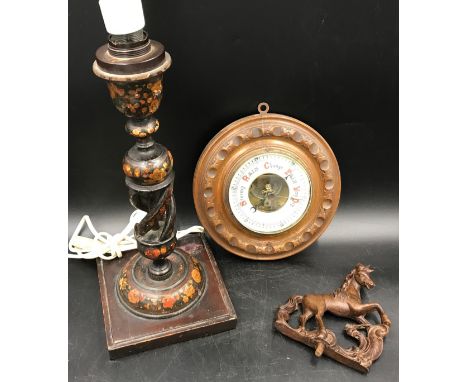 A carved oak circular wall barometer 21cms w, a painted wood table lamp with open twist stem 38cms h and a clock top finial i