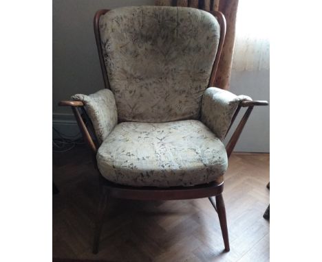 An Ercol armchair. 100cm h x 75cm w x 85cm d.Original upholstery, slight fade and wear with age and use.