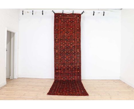 A Hamadan runner,with geometric motifs to a red field, and triple border,407 x 100cmCondition ReportPossibly shortened - 'cut