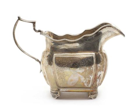 A George III Irish silver cream jug,by James Le Bas, Dublin 1818, with a beaded rim above a floral and foliate engraved body,
