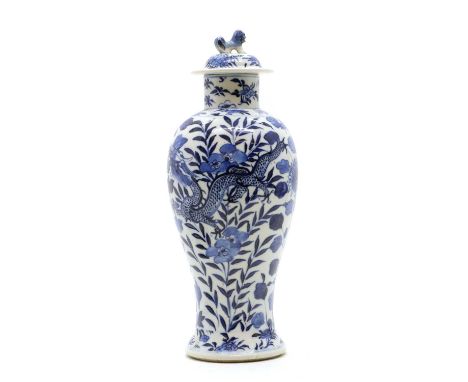 A Chinese blue and white vase,19th century, of baluster form, painted with a pair of dragons among peony and leaves, the dome