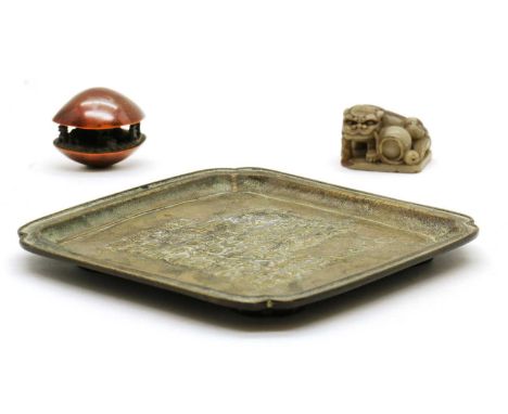 A Chinese hardstone seal,20th century, of a Buddhist lion and a ball, seal face inscribed,3.5cm long, a brass tray, of shaped