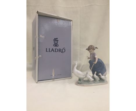 A boxed Lladro figure of a child with a gaggle of geese