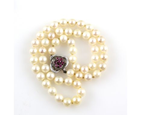A cultured pearl necklace with pearls of 7-8 mm to a ruby set white metal clasp, testing as 9 ct gold, strung with knots, len