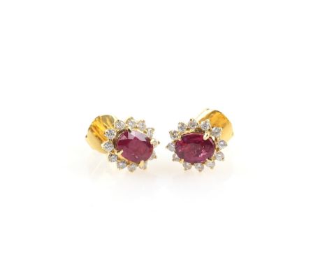 A pair of ruby and diamond earrings, oval faceted stones within a border of diamonds, in unmarked yellow gold. NB the rubies 