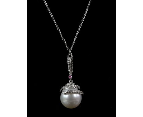 Modern pearl and diamond pendant, set with a white pearl, 10mm in diameter, with diamond set detail and one single ruby set i