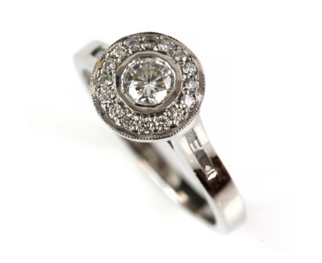 Diamond halo ring, set with round brilliant cut diamonds, with diamond set under gallery, baguette cut diamond set shoulders,