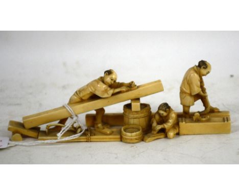 A stained ivory okimono designed as a group of three wood workers; 13.5 cm long, Meiji PeriodPLEASE NOTE: THIS ITEM CONTAINS 