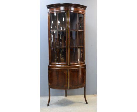 19th Century mahogany bow fronted display cabinet, the top with two glazed doors and the base with two panelled doors on spla