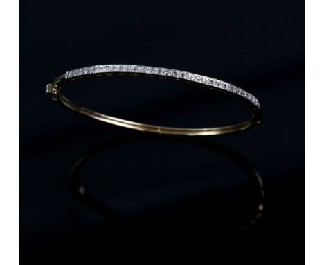 Modern diamond set oval hinged bangle, set with Swiss cut diamonds, estimated total diamond weight 0.30 carats, with conceale