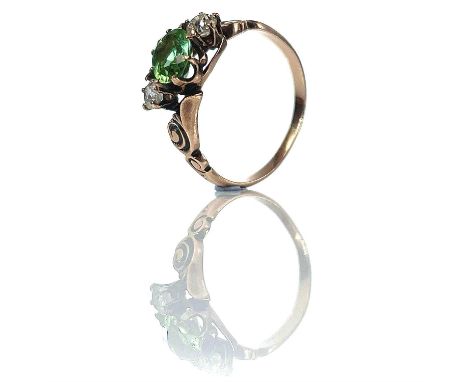 A gold diamond and green tourmaline three stone ring, the oval cut tourmaline measuring 0.50ct and flanked by two diamonds ea