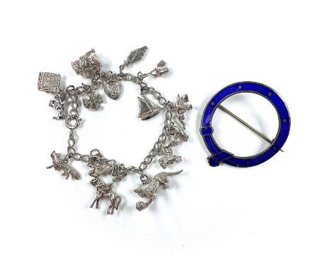 A sterling silver and blue guilloche enamel garter brooch, diameter 43mm; together with a silver charm bracelet, weight overa