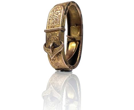 A 9ct rose gold scarf clip, foliate engraved and in the form of a belt, stamped 9ct, width 40mm, weight 11.58g.
