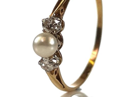 An 18ct diamond and pearl set three stone ring, the pearl measuring 4mm diameter, flanked by two diamonds each measuring 0.05