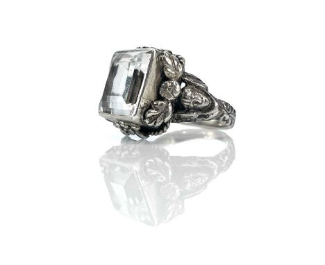 An Arts &amp; Crafts silver rock crystal set ring, the square step cut stone measures 12mm x 11mm, in a collet setting applie