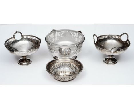 A PAIR OF SILVER SWEETMEAT DISHES with a pierced gallery and three ring handles, 10cm diameter, Birmingham 1945 by Mappin & W